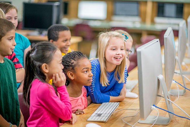 picture of 3 children smiling in the classroom